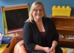 BHC graduate sitting in a child's waiting area on a beanbag chair