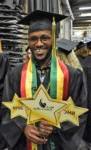 Graduate wearing black cap and gown holding BHC 2019 sign