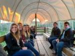 smiling students on a hayrack ride