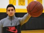 college basketball player holds a basketball out