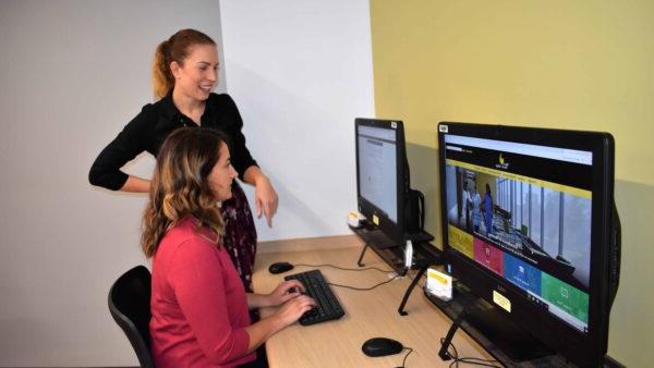 Financial Aid director helping a student sitting at a computer